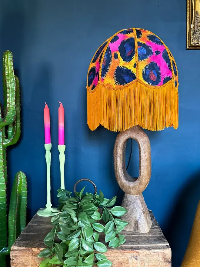 Vintage Fringed Dome Lampshade In Electric Leopard, in a room. 