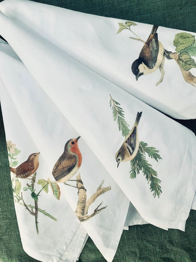A set of four white cotton napkins printed with garden birds