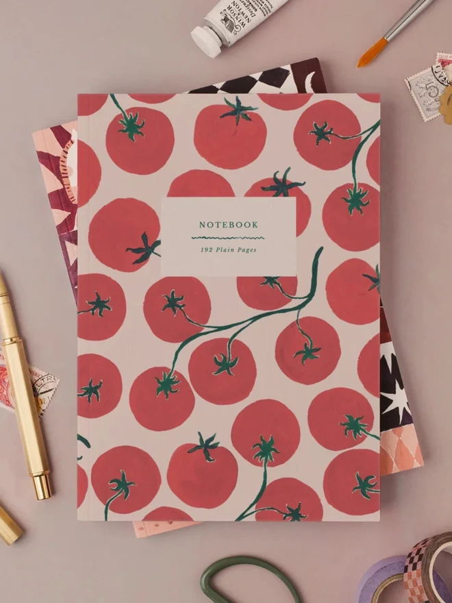Tomatoes Notebook with a gold pen and art supplies