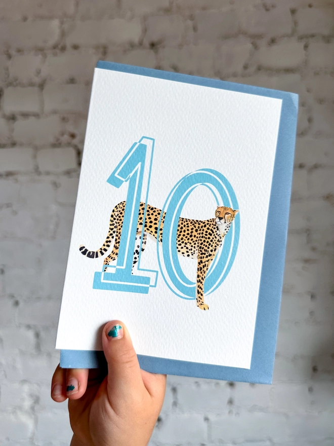 a white card with a big blue number 10 and an illustration of a cheetah with a pale blue envelope