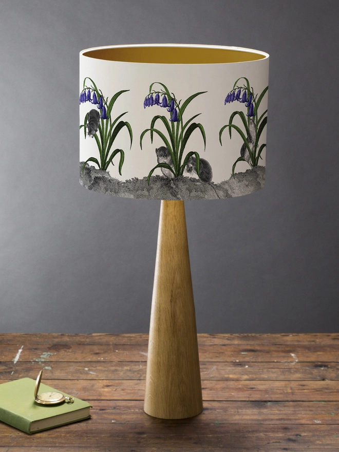 A whimsical lampshade featuring adorable mice hiding among bluebells, creating a charming woodland-inspired design.