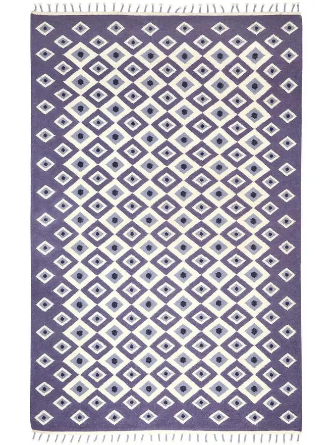 Evil Eye Flatweave Rug, a colourful rug on a plain surface. 