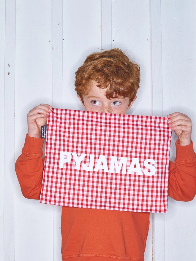 Red gingham pyjama case with white writing