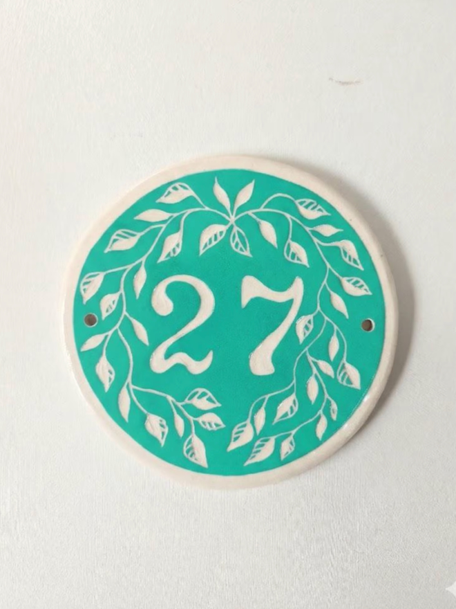 Custom Round Ceramic House Number with Leaves. A house number in turquoise.
