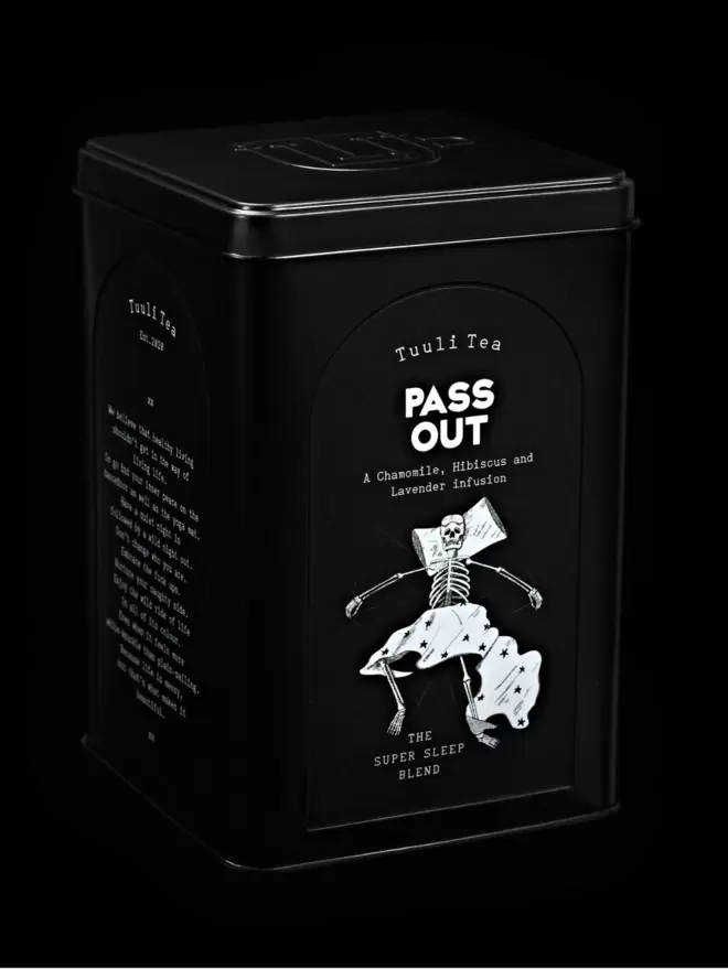 A black tin of Pass Out herbal tea photographed on a black background. 