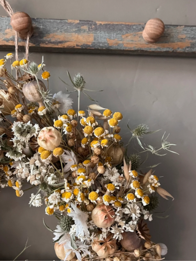 Autumnal Wreath. A wreath made of dried autumnal flowers, hung on a wall.