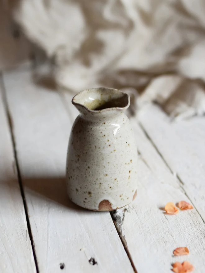 Wavy stoneware bud vase. A small stoneware bud vase with a wavy rim