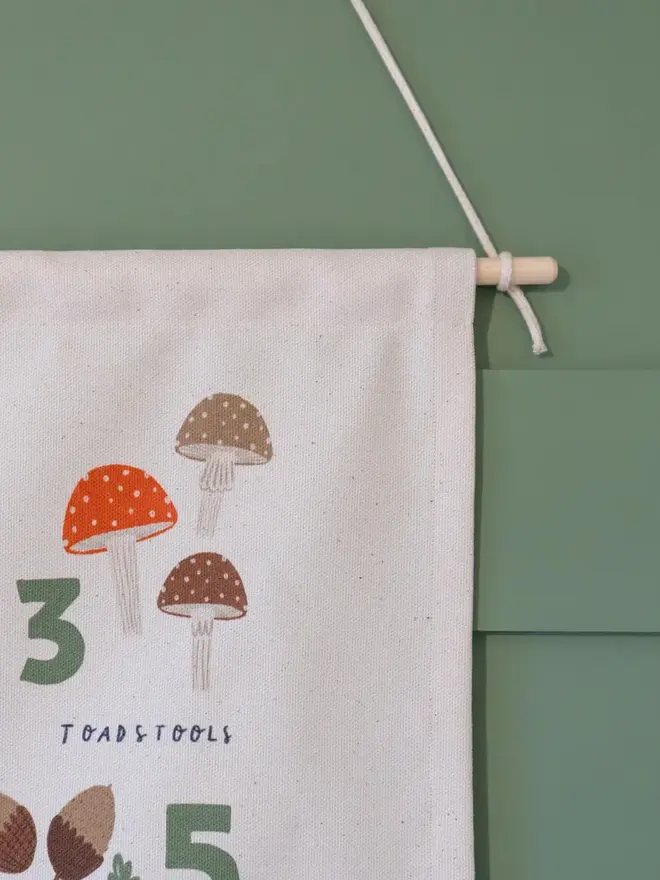 Woodland Numbers Fabric Banner, against a green wall. 