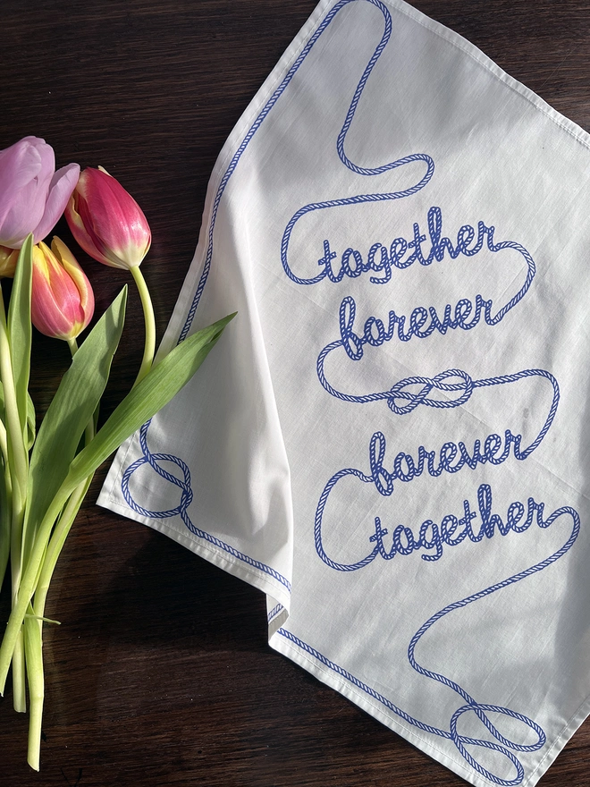 Together Forever Romantic Handkerchief on a table with tulips