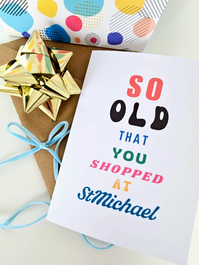  A photograph of the front of a humorous A6 greeting card illustrated using brightly coloured text and the retro shop logo. The text says so old you shopped at St Michael.