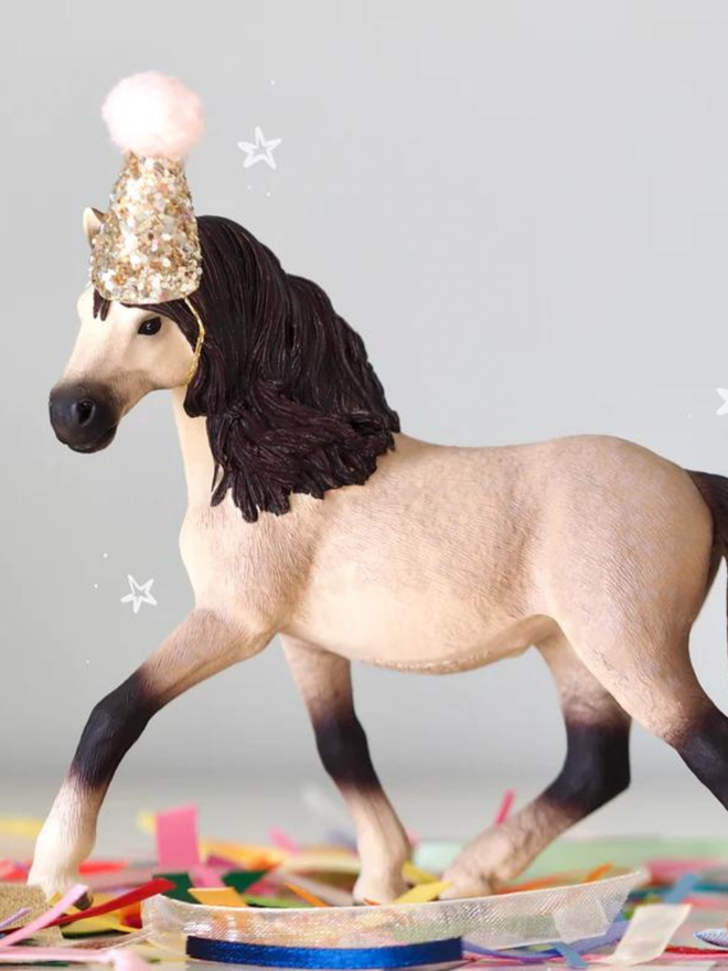 Andalusian mare seen with a sparkly pom hat.
