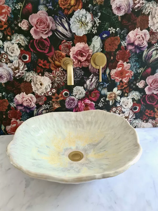 Ceramic bathroom basin, hand-crafted basin, sink, wc, bathroom, ensuite, modern bathroom, photographed against colourful floral wallpaper with gold taps