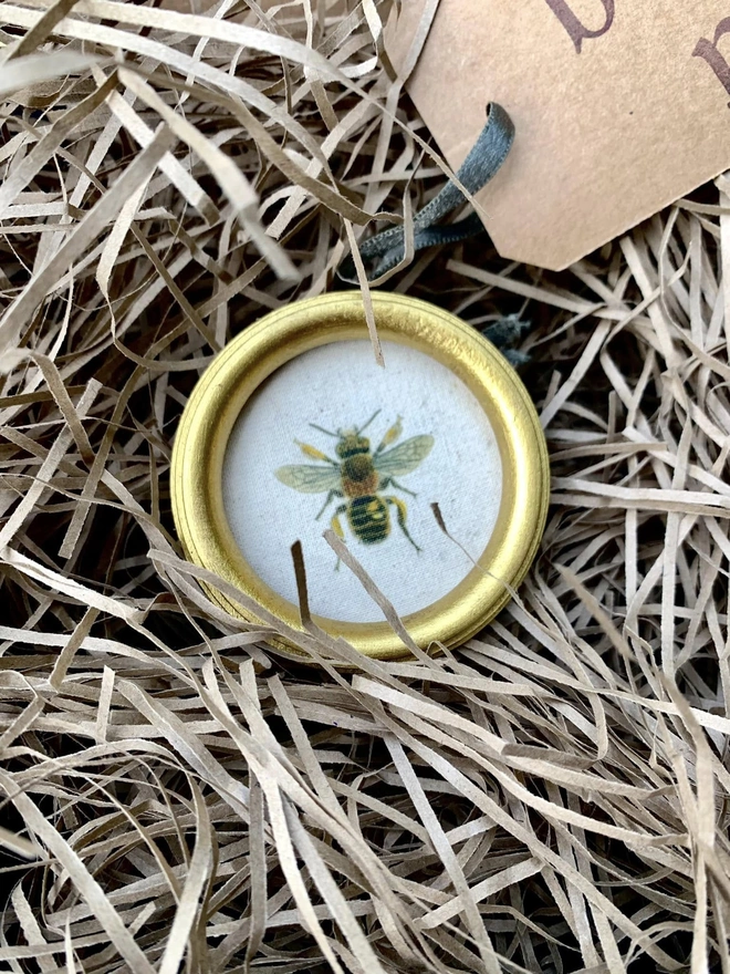 Round gold frame with bee print