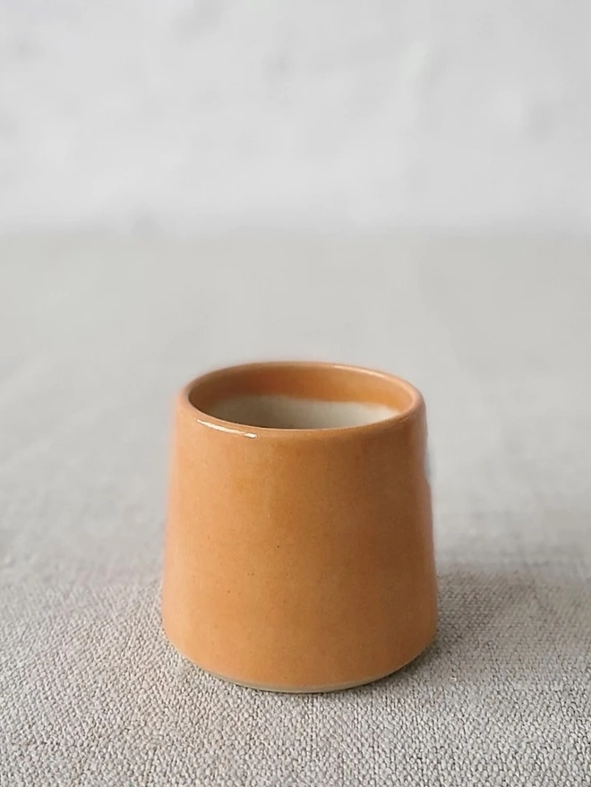 Classic Handmade Egg Cup, a ceramic egg cup sitting on a carpet surface against a grey backdrop. 
