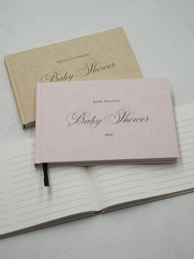 Personalised Baby Shower Guestbook. A hardcover linen embossed guest book with Baby Shower written across the middle in a calligraphy font and personalised with a name at the top and date at the bottom