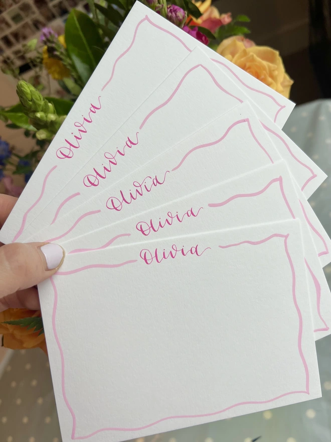 Five white notecards with pink wavy borders and Olivia written at the top of the notecard