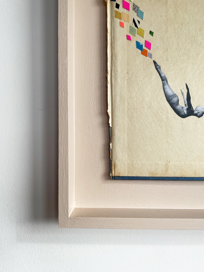 A female swimmer performs the perfect swan dive into the swimming pool below. A framed collage made with vintage papers and pops of neon pink with torn edges and interesting textures.
