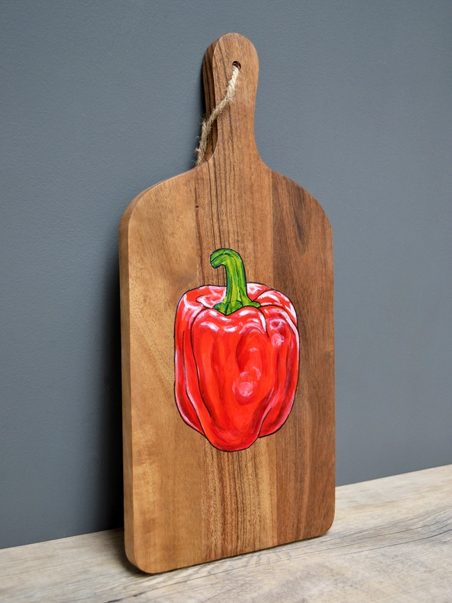 Wooden serving board with handpainted red pepper design