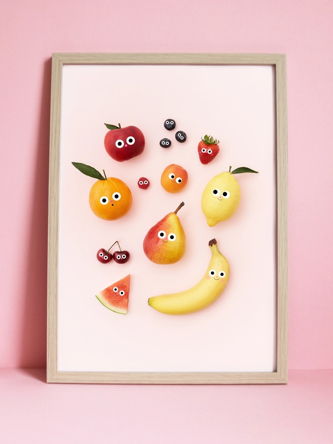 A framed A3 Print of fruit with faces 