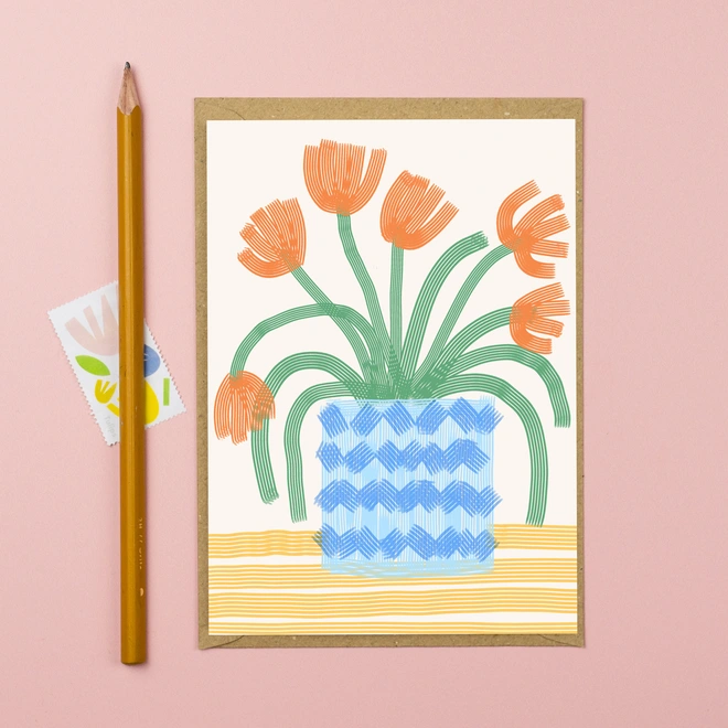 An illustration of red tulips in a blue pot on a yellow striped tablecloth,