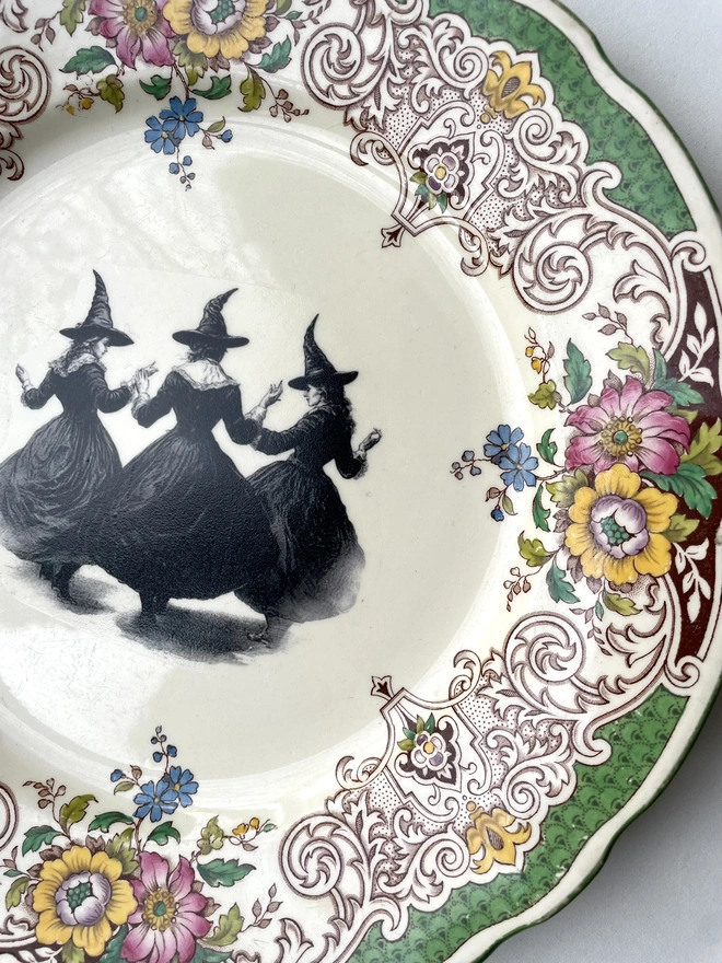 a vintage plate with an ornate floral border in the centre is a witch's coven