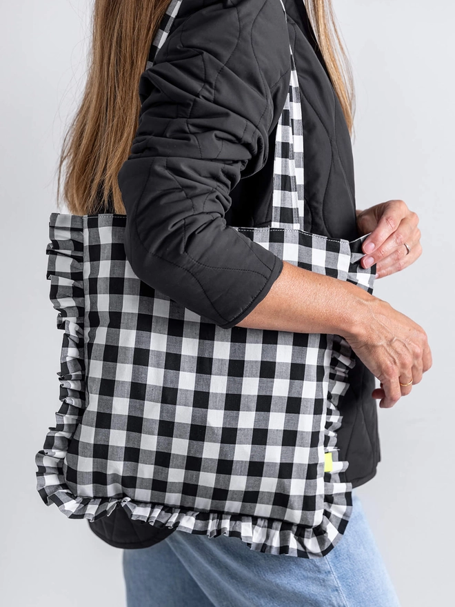 Lady with black and white check pattern tote bag on shoulder