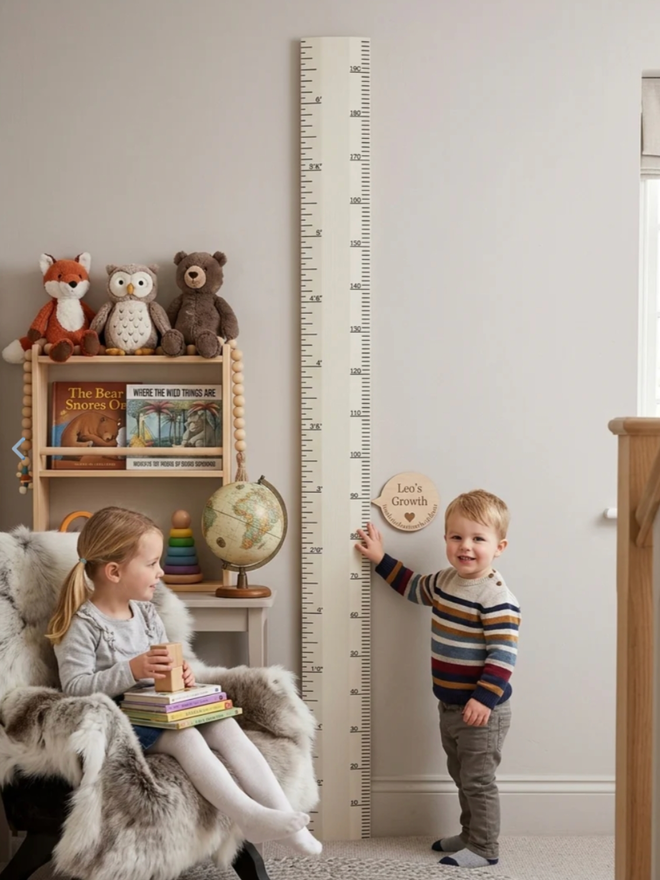 Wooden Height Chart. A large ruler height chart in Pointing leaning against a child’s wall.