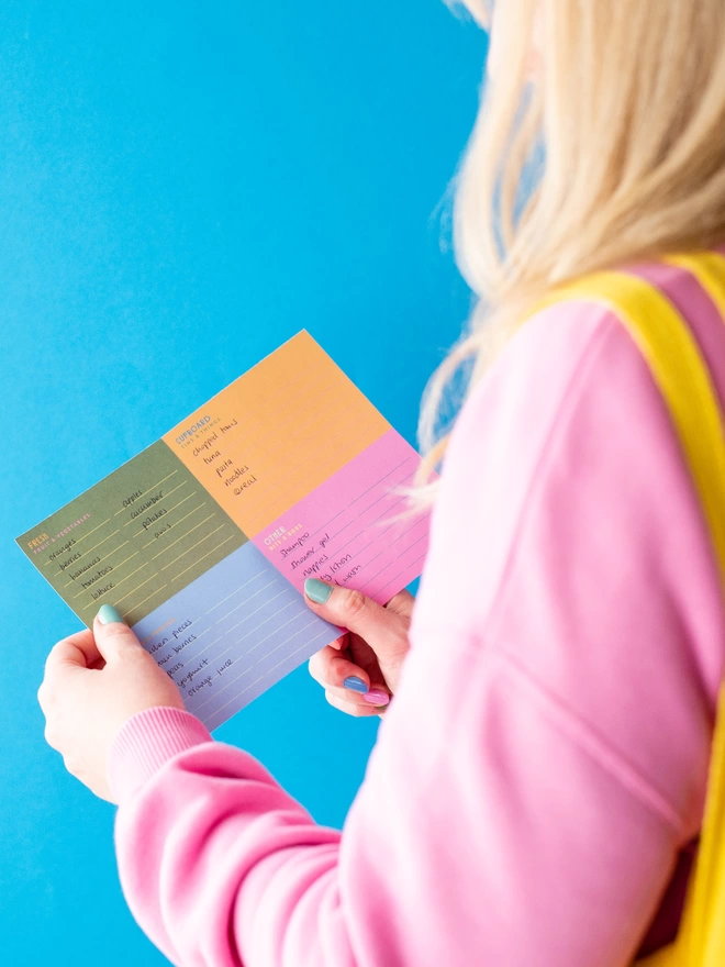 Holding the Raspberry Blossom colourful tear off shopping list 