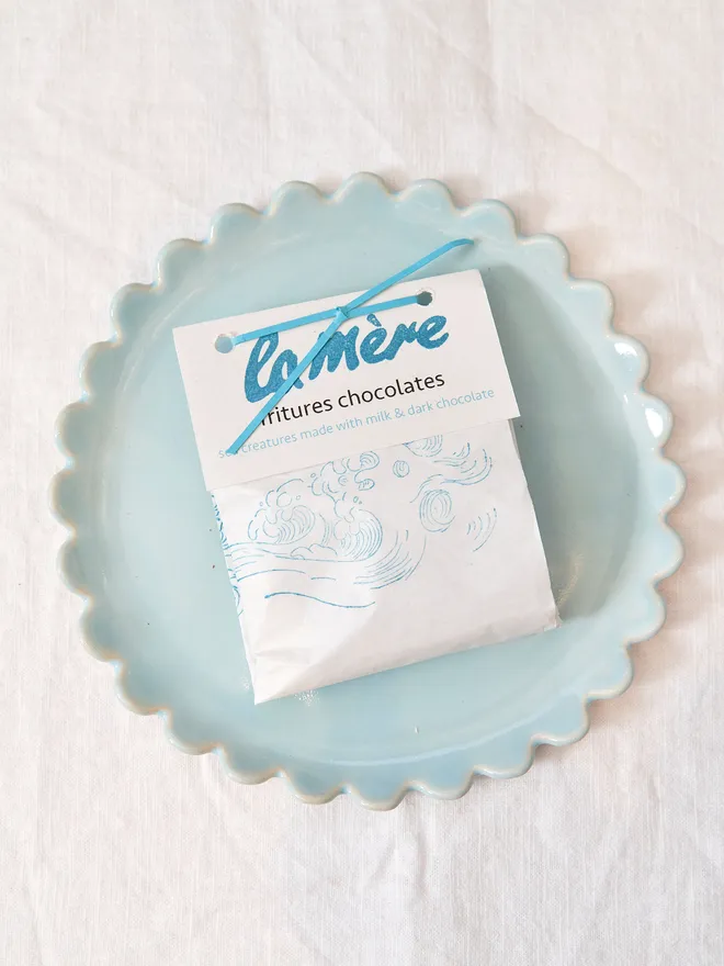 white paper pouch with blue decor, on blue ceramic plate