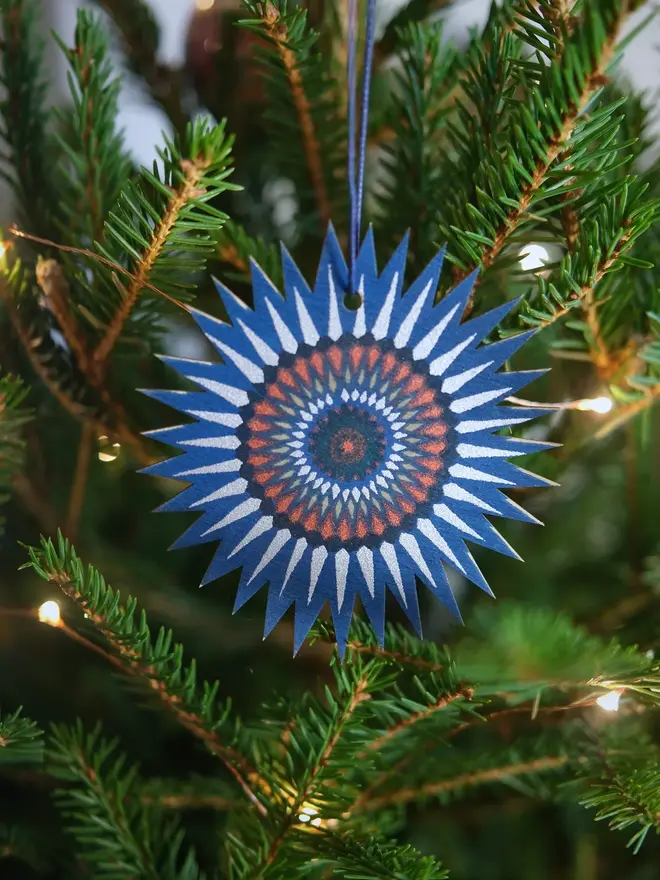 star wooden ornament on christmas tree