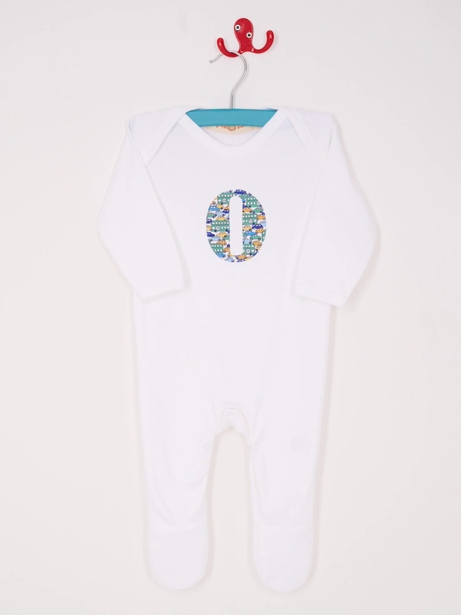 a personalised cotton baby romper with an initial in Liberty print on the front