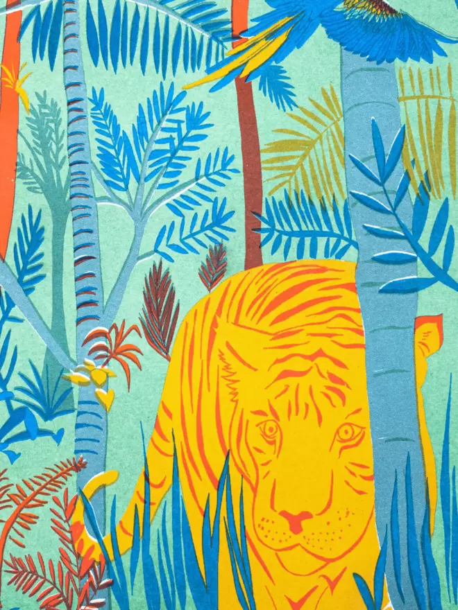 Close-up, detailed shot: yellow and orange tiger behind the blue trees