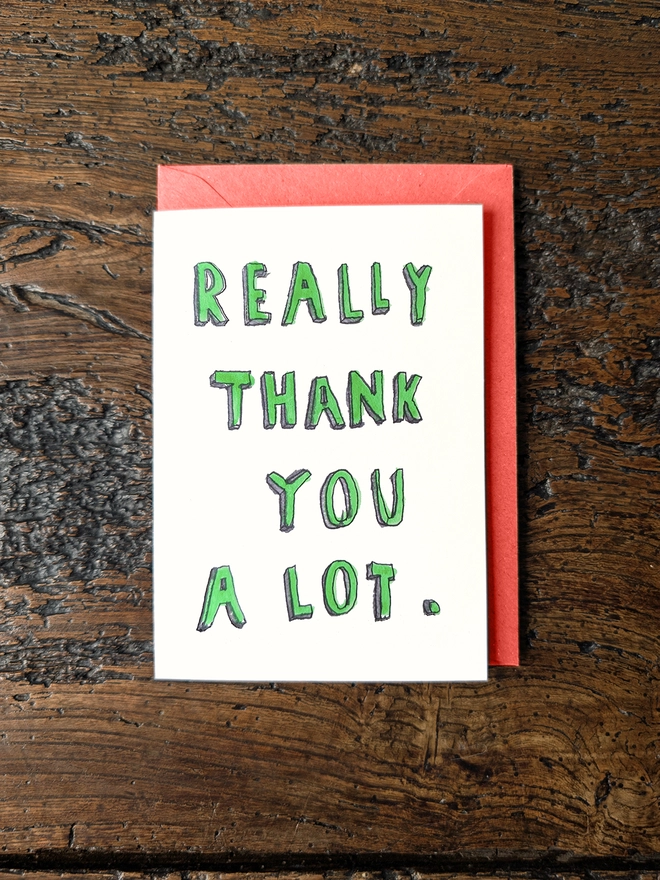 a card that says really thank you a lot hand finished with fluorescent green paint flat lay