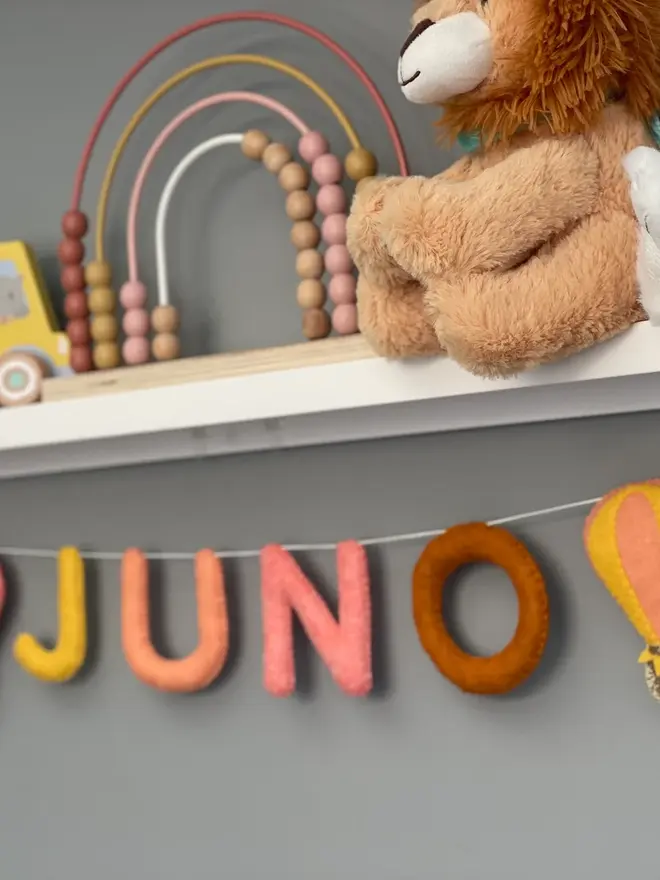 Personalised Name Icon Garland, a child's name banner hanging from a white shelf, nursery decoration, baby gift 