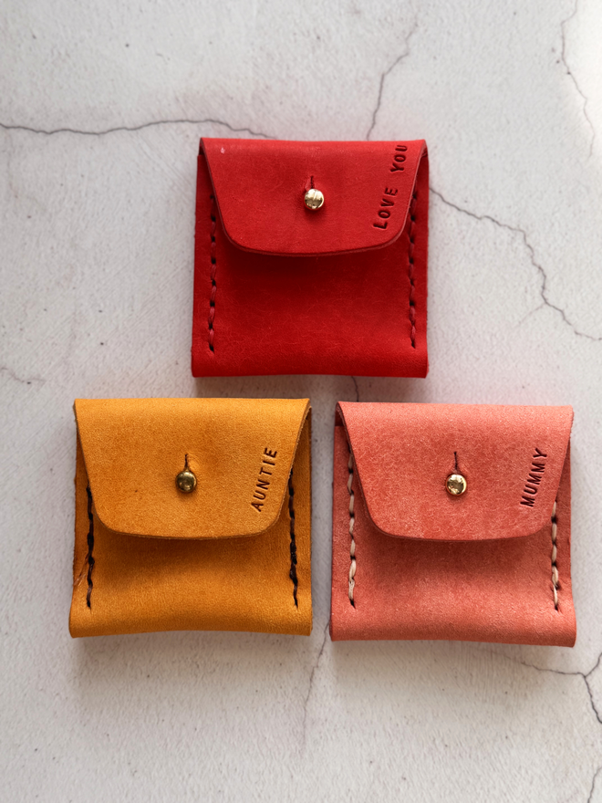 3 leather coin purses, in red, yellow and pink