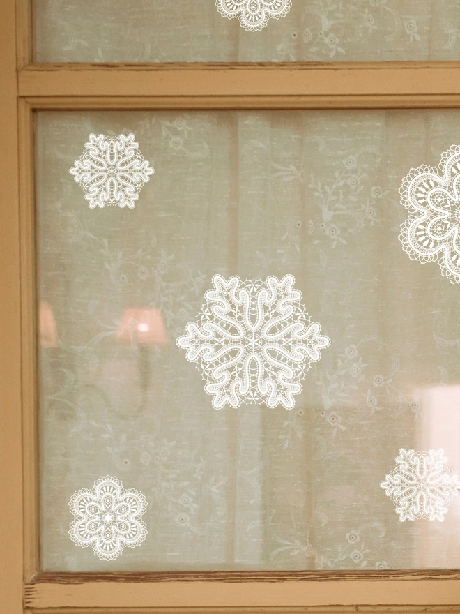 lace snowflakes static cling christmas decals on a interior glass door back with lace netts