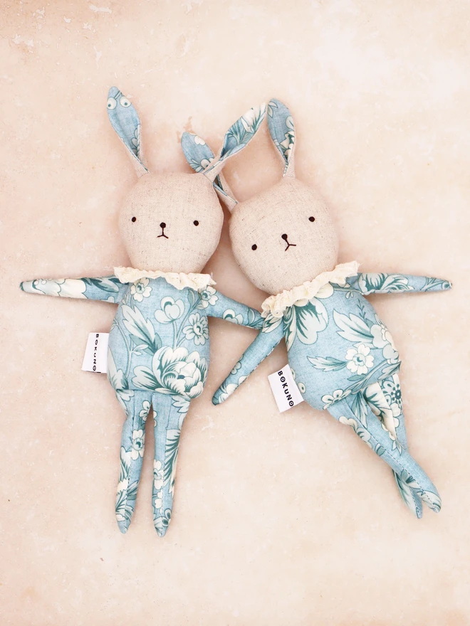 Handmade bunny dolls in blue vintage floral print outfit and frilly lace collar, natural linen face with hand embroidered face feature.