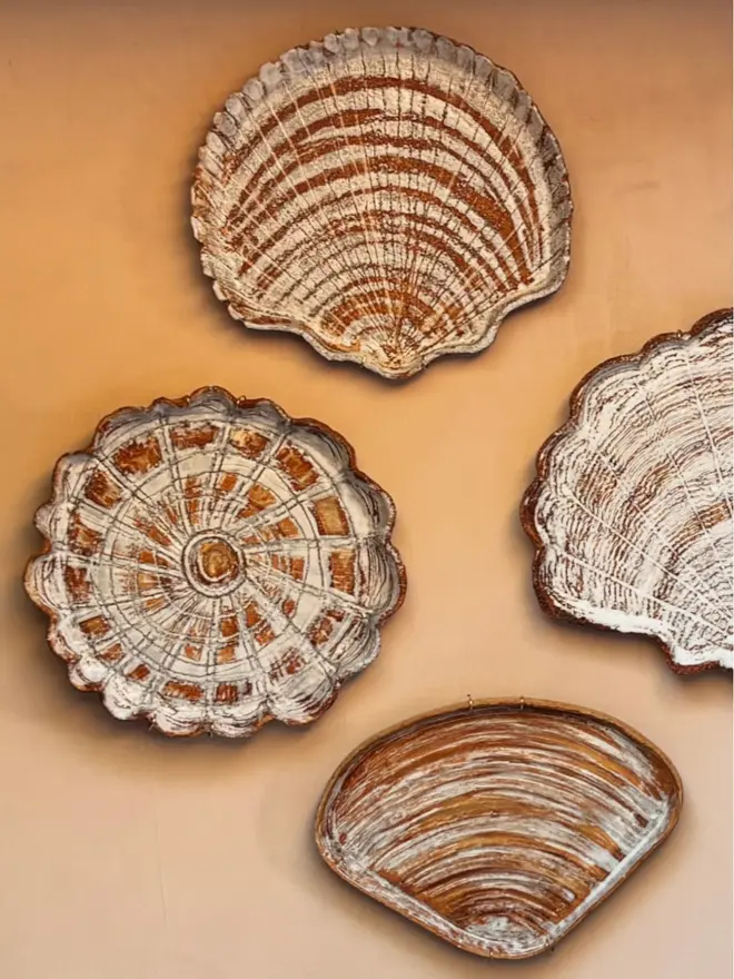 Group Shot Ceramic Shell Plate on orange wall