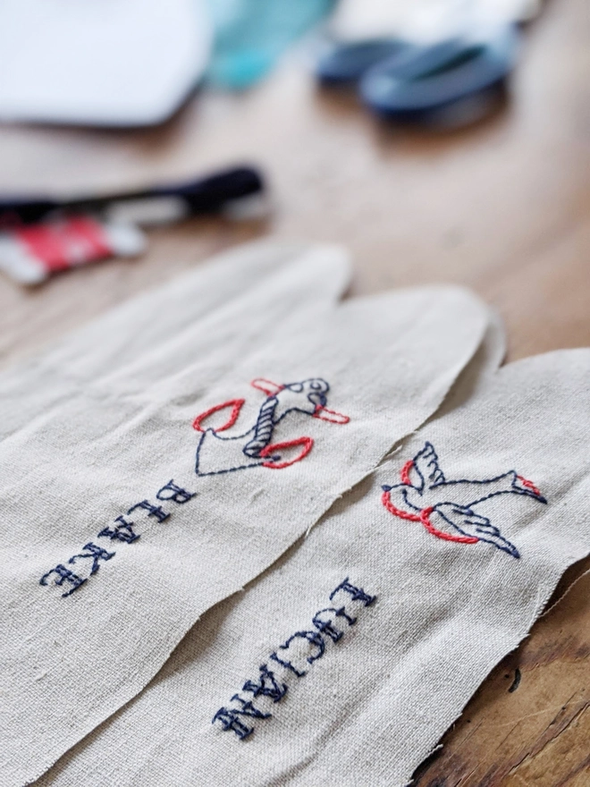 Handembroidery with swallow and anchor, personalised name embroidered underneath on cream linen 