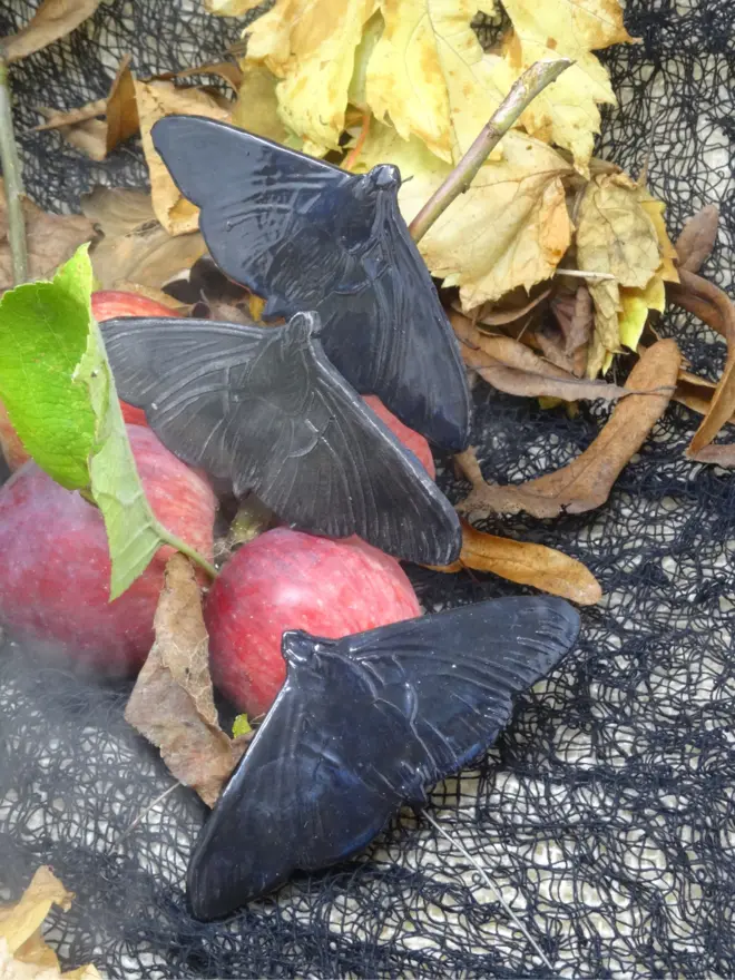 Three black ceramic moth decorations