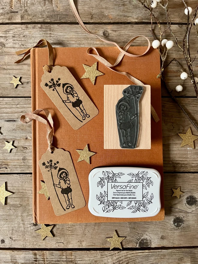 swing tags stamped with a woodland pixie  and the traditional wooden stamp next to them and the ink pad