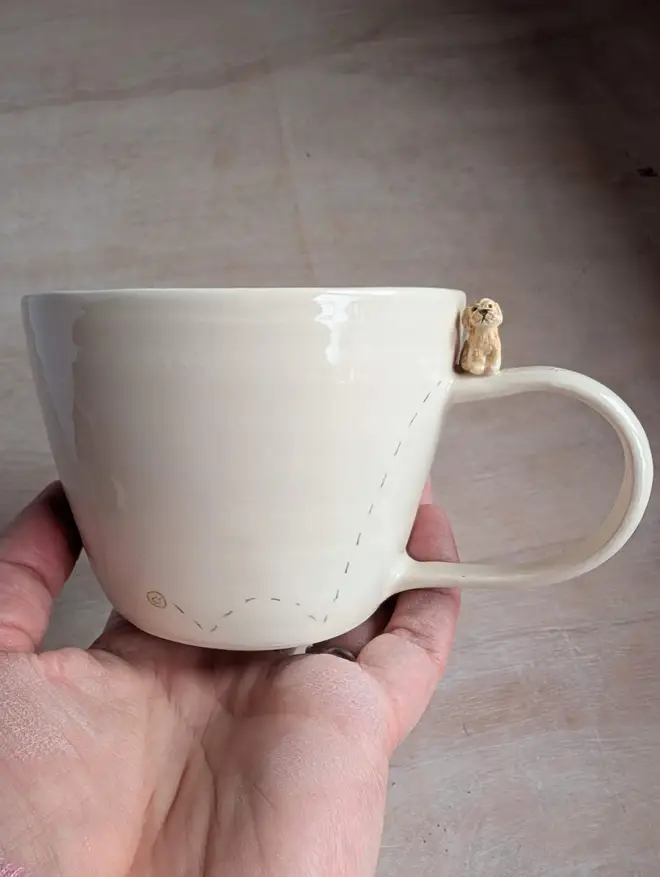 Cockapoo cup with a tiny ceramic dog on the handle 