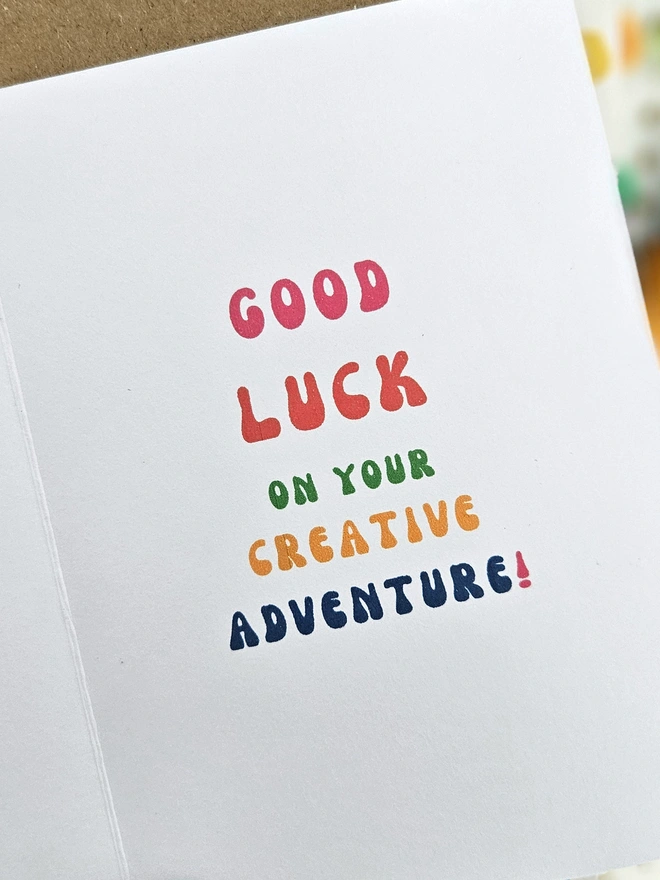 A colourful card using retro typography on a white background that says Good Luck on your creative adventure