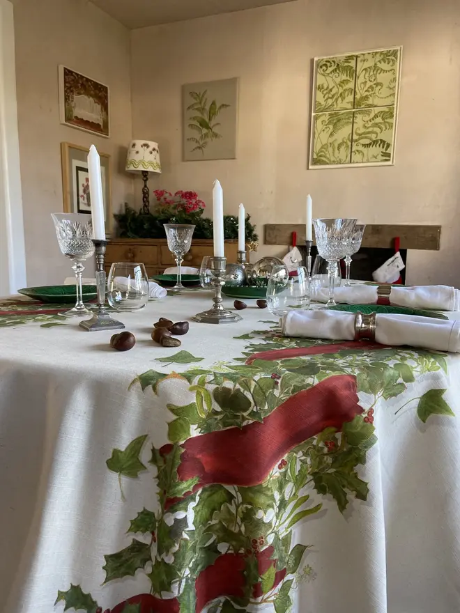 christmas double garland tablecloth. a white table cloth with two painted christmas garlands on a table.