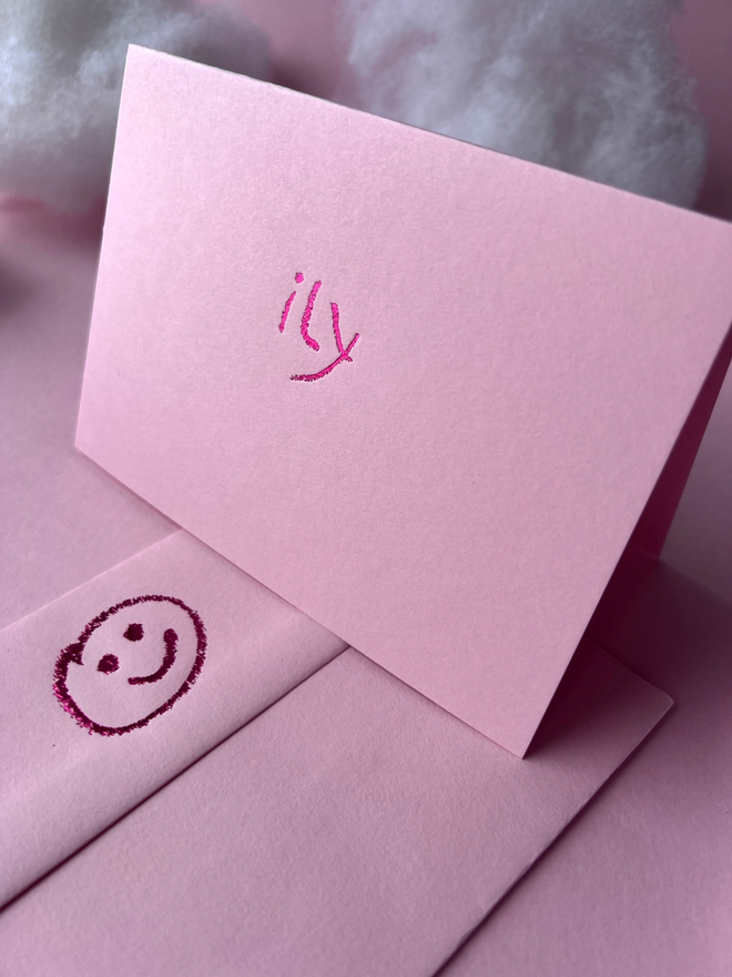 pastel pink coloured card with ily  short for 'I love you' hand foiled in kids hand writing