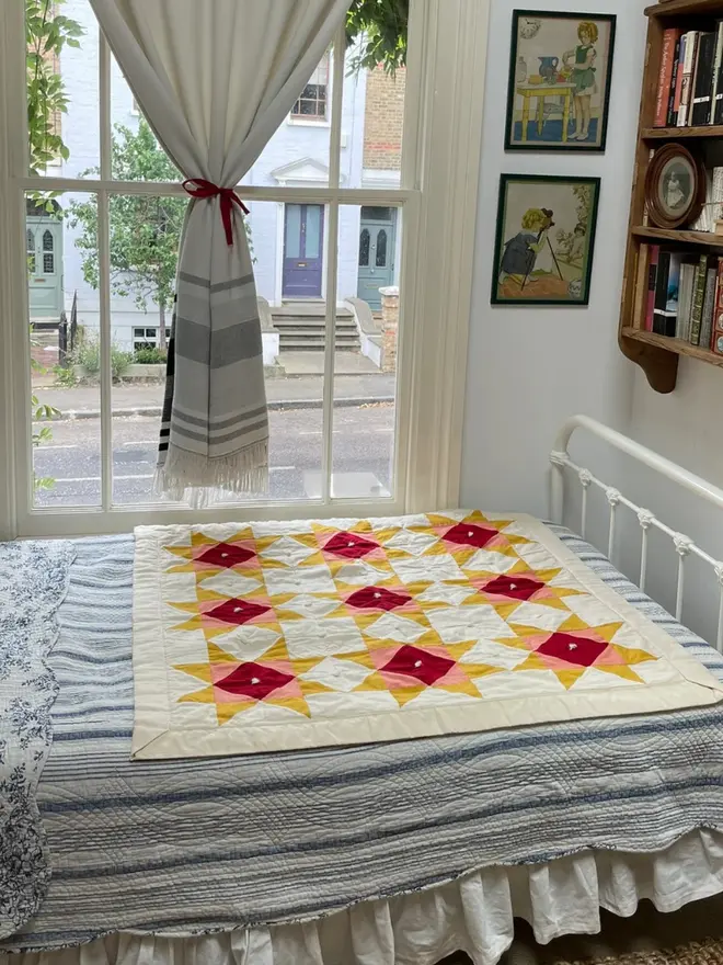 Warm Hearth Patchwork Quilt, on a bed. 