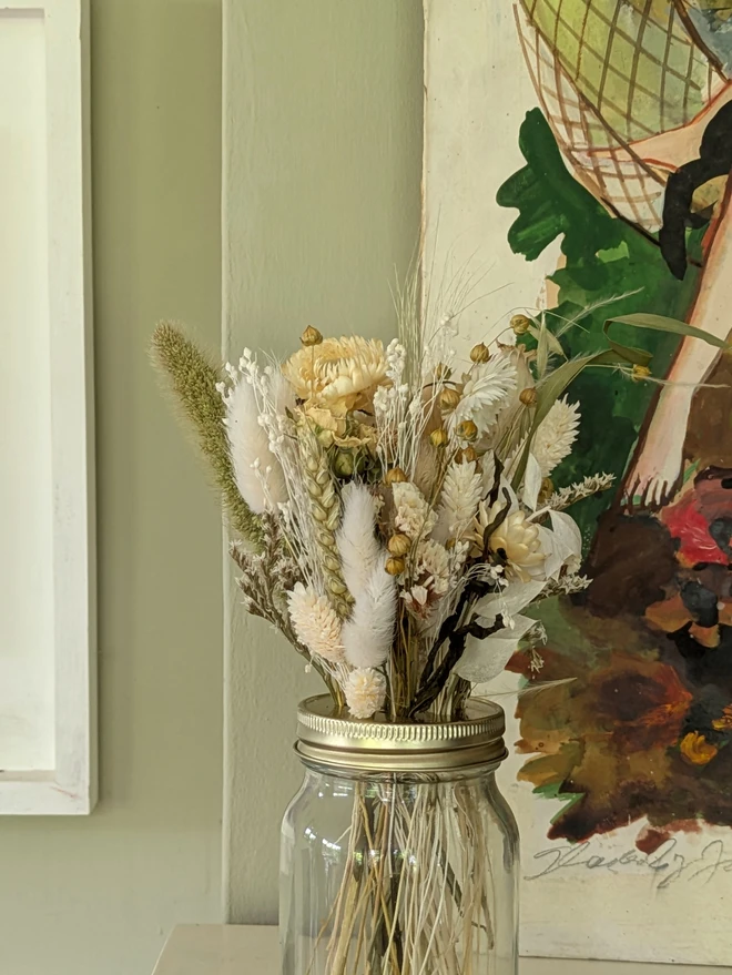 white and natural dried flowers in a glass jar