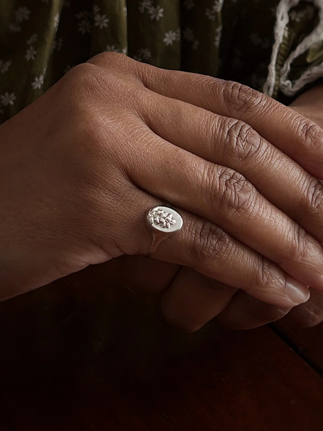 Sterling Silver Signet Ring close up with a real heather flower cast representing protection in the language of flowers worn by a model