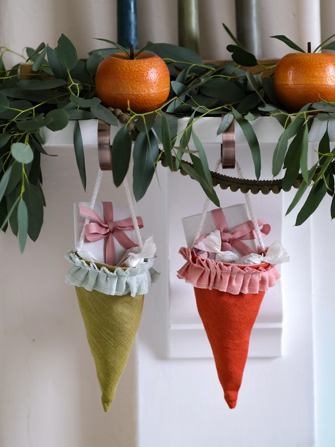 Reusable Victorian Christmas gift cones for hanging beneath festive greenery, featuring delicate ruffled trim.