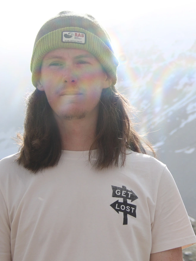 Man wearing a white t-shirt with a small graphic on the front that says 'get lost'